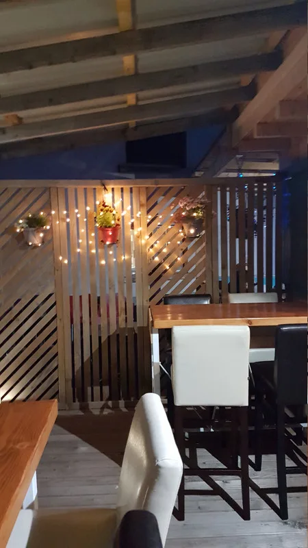 Le coin cosy de la salle — guirlandes lumineuses et plantes.